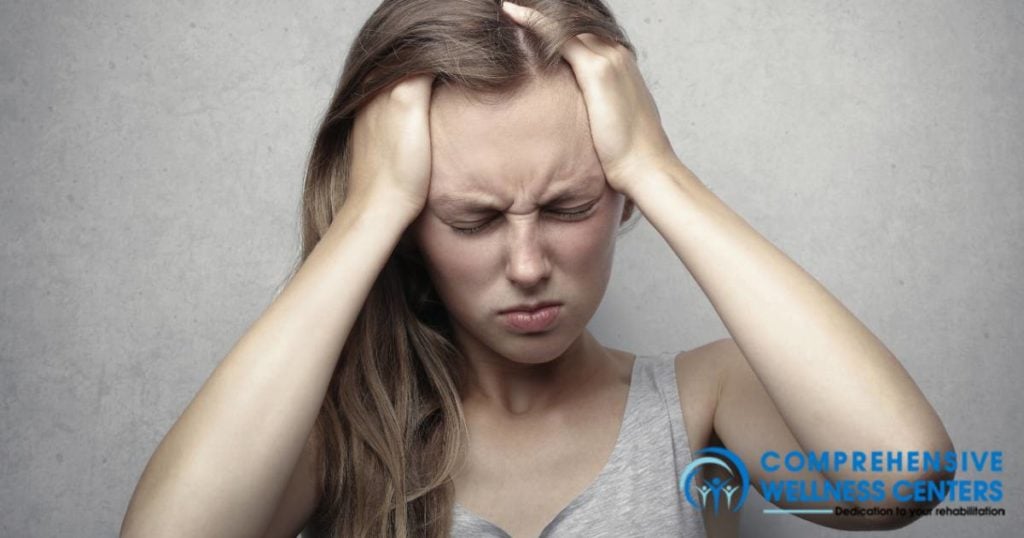 girl with headache from post-acute withdrawal syndrome holding her head